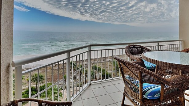 A balcony with a view of the ocean, wicker furniture, and a railing. - Indigo East #705 | Luxe Gulf Front Condo + Amenities (Perdido Key)