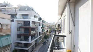 A residential building with multiple balconies, a street view, and parked cars. - Heart of Athens 1 Bedroom (Athens)