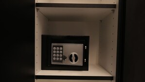 Una cassaforte sicura con serratura a combinazione, alloggiata in un armadietto nero con interno bianco.