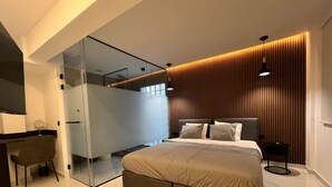 A modern bedroom with a bed, a desk, and a chair. - Signature Suites - Athinas (Athens)
