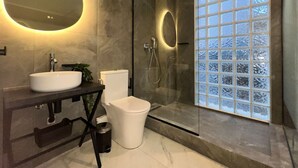 A modern bathroom with a large mirror, a sink, a toilet, and a glass-enclosed shower. - Signature Suites - Athinas (Athens)