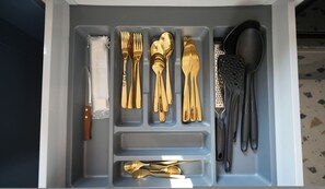 A drawer with compartments containing various utensils, including forks, spoons, and a grater. - Loutraki Beach Bliss 3 min to Beach (Loutraki-Agioi Theodoroi)
