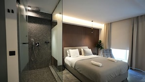 Une chambre d’hôtel moderne dotée d’un grand lit, d’un espace douche et offrant une vue sur l’extérieur.