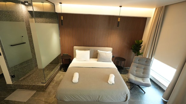 Une chambre d’hôtel moderne dotée d’un grand lit, d’une douche et d’un coin salon.