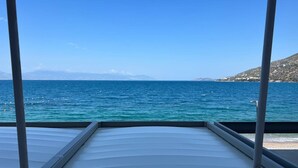 A view from a boat deck with a clear blue sea and distant land. - Loutraki Seaview Firstline (Loutraki-Agioi Theodoroi)