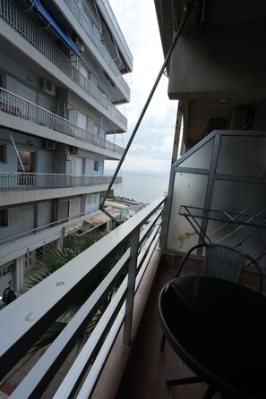 A balcony with a view of the sea, a metal chair, and a railing. - Beachfront Escape Seaview (Loutraki-Agioi Theodoroi)