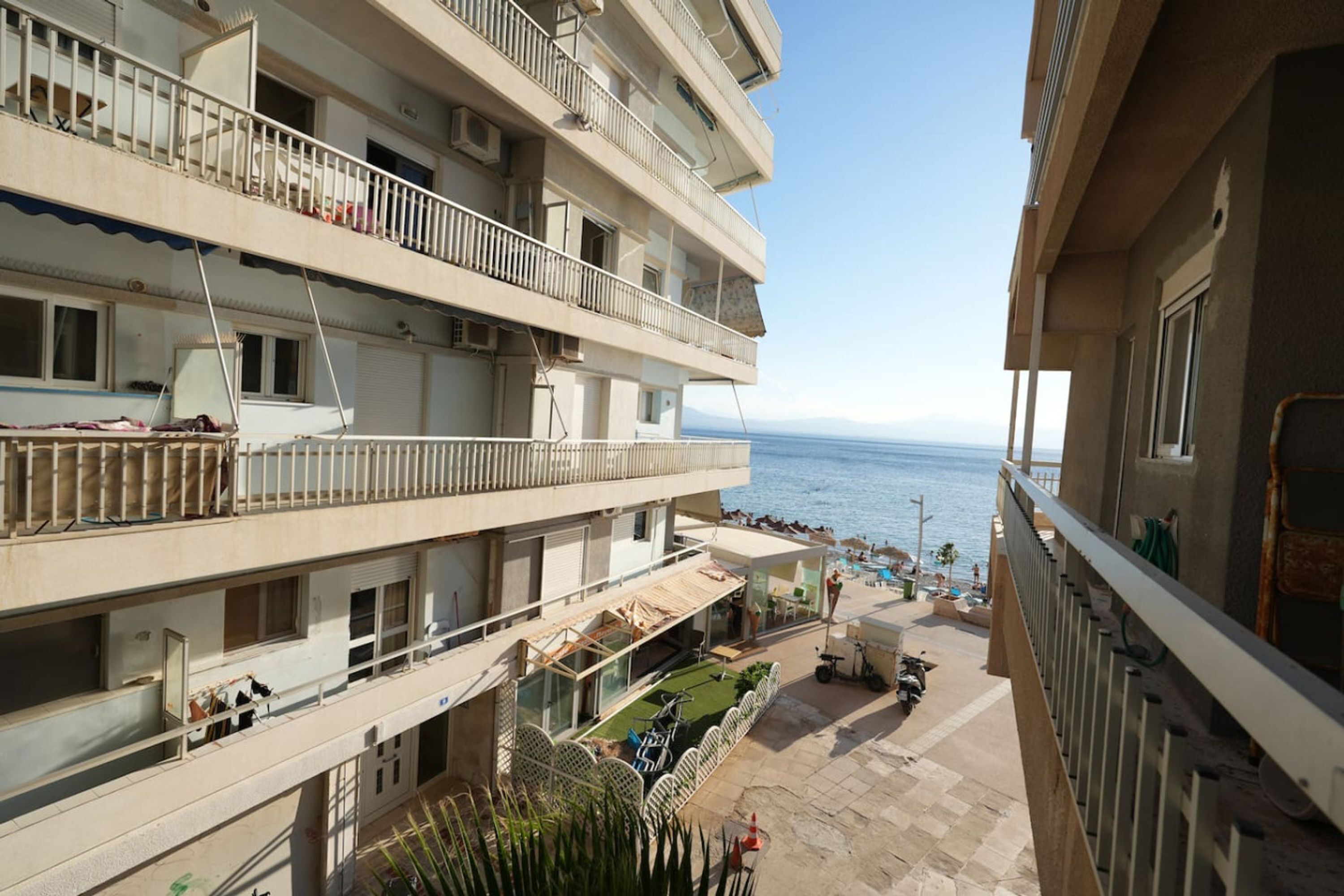 Un hôtel à plusieurs étages doté de balcons donnant sur une plage.