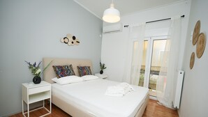 Una camera da letto con un letto, comodini, abat-jour, una lampada a soffitto, una finestra con tende e una decorazione a parete.