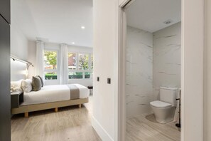 A modern bedroom with a bed, bedside table, and a view of the outside. - Dobo Alcorcón VG29 (Alcorcón)
