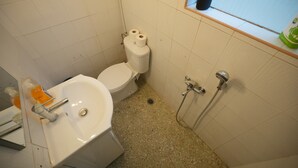 Ein kleines Badezimmer mit Waschbecken, Toilette und Dusche.