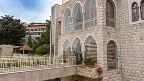 Un bâtiment en pierre doté de fenêtres en arc de cercle et d’un balcon.
