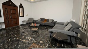 A modern living room with a sectional sofa, a coffee table, and a fireplace. - The Ajaltoun Villa in Ajaltoun (Ajaltoun)