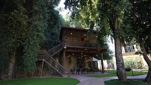 A rustic wooden cabin with a balcony and outdoor seating area surrounded by lush greenery. - Keserwan s Hillside Resort and Venue (Aazra Wil Aazr)