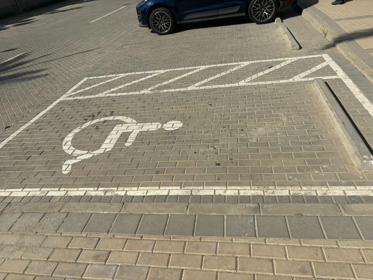 A parking area with a disabled parking space marked by a wheelchair symbol.