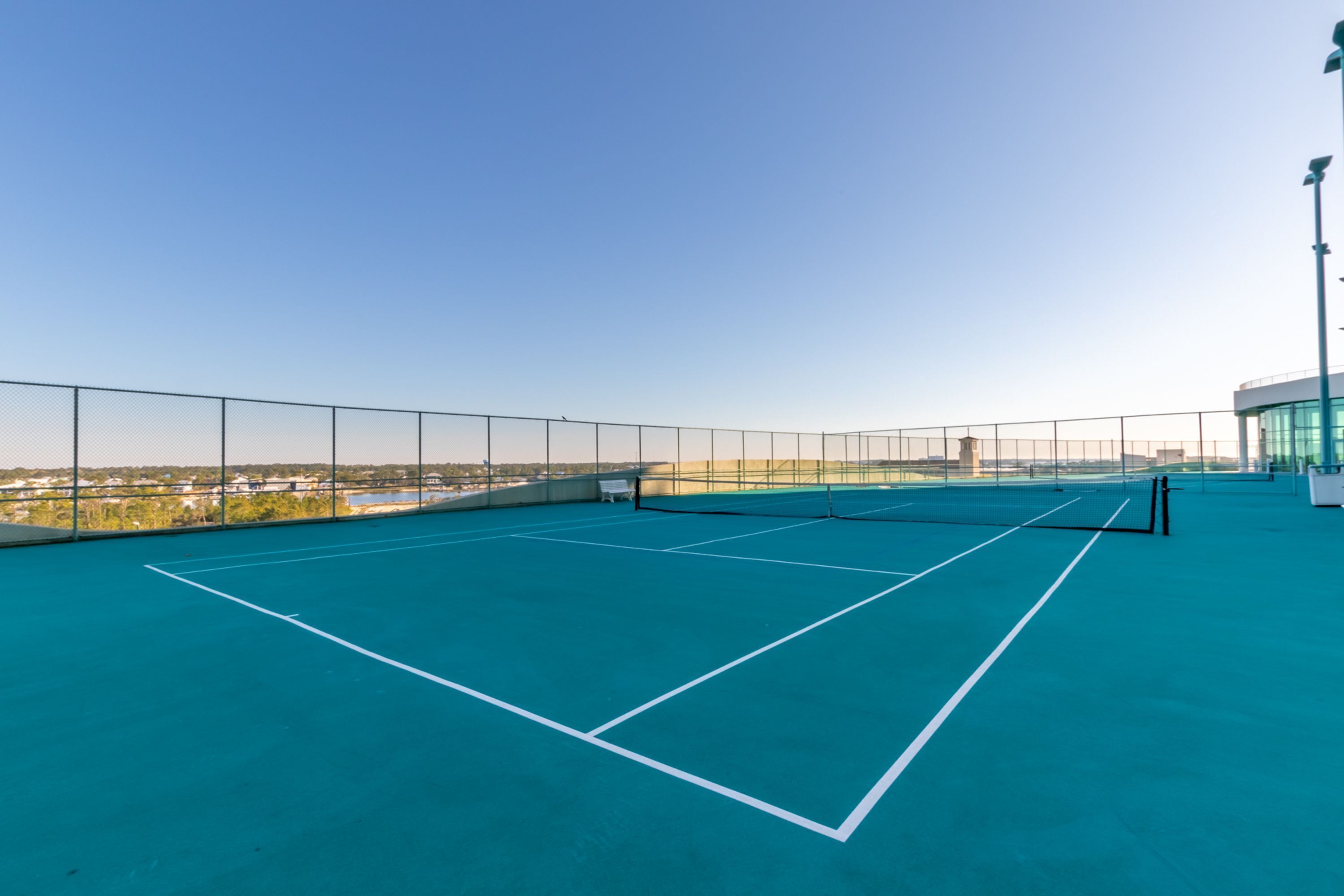 Una cancha de tenis al aire libre con vistas despejadas del entorno.
