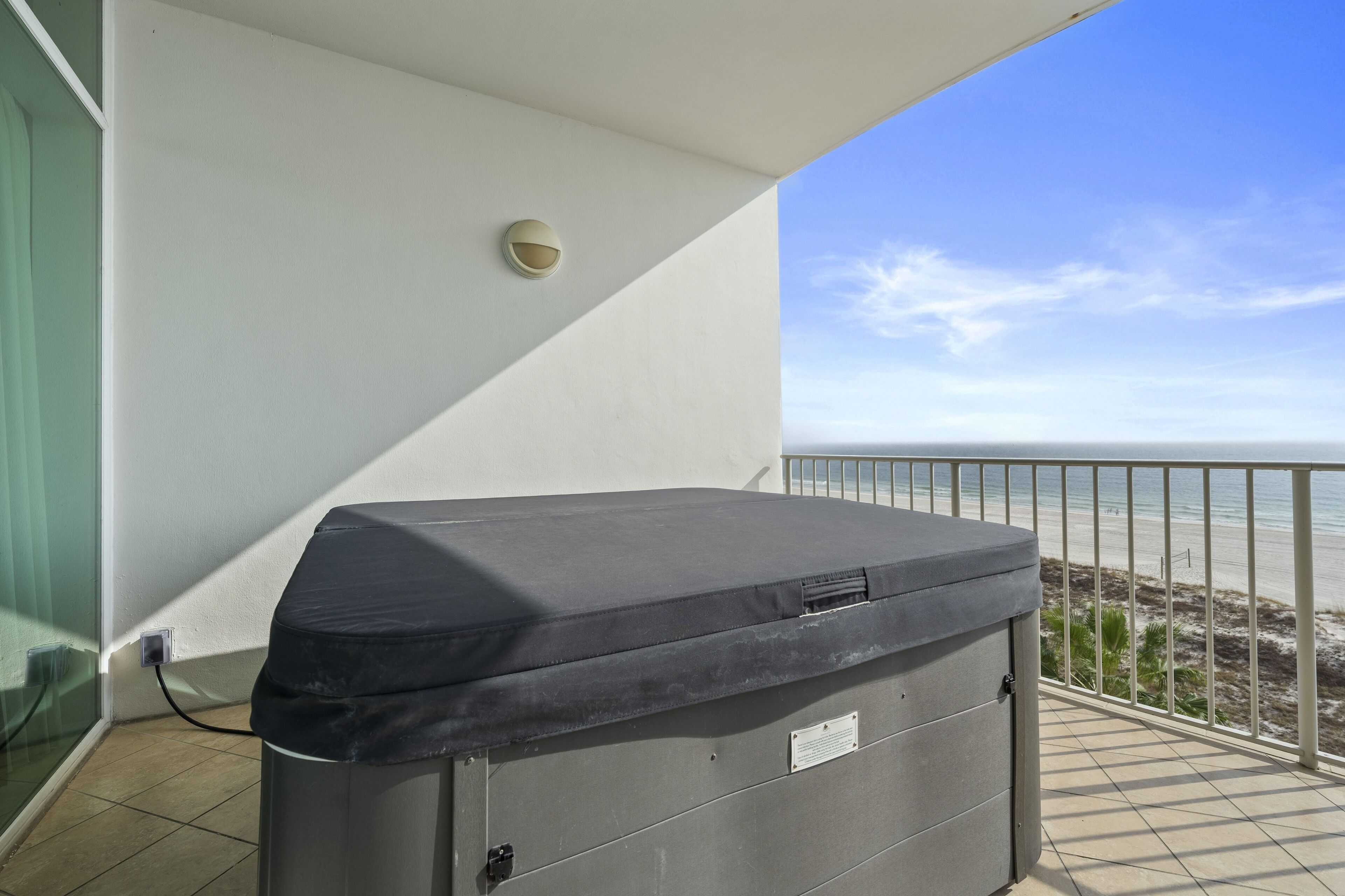A covered outdoor seating area with a view of the beach.