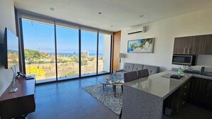 A modern kitchen with a large island, a dining area, and a view of the ocean. - Torres Mittah (La Cruz de Huanacaxtle)
