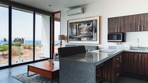 A modern kitchen with a large island, dark wood cabinets, and a view of the beach. - Torres Mittah (La Cruz de Huanacaxtle)