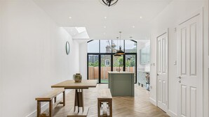 Una cocina moderna con una mesa de madera, bancos y una isla central.