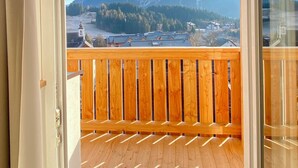 Ein Holzbalkon mit Blick auf einen Berg und eine Stadt.