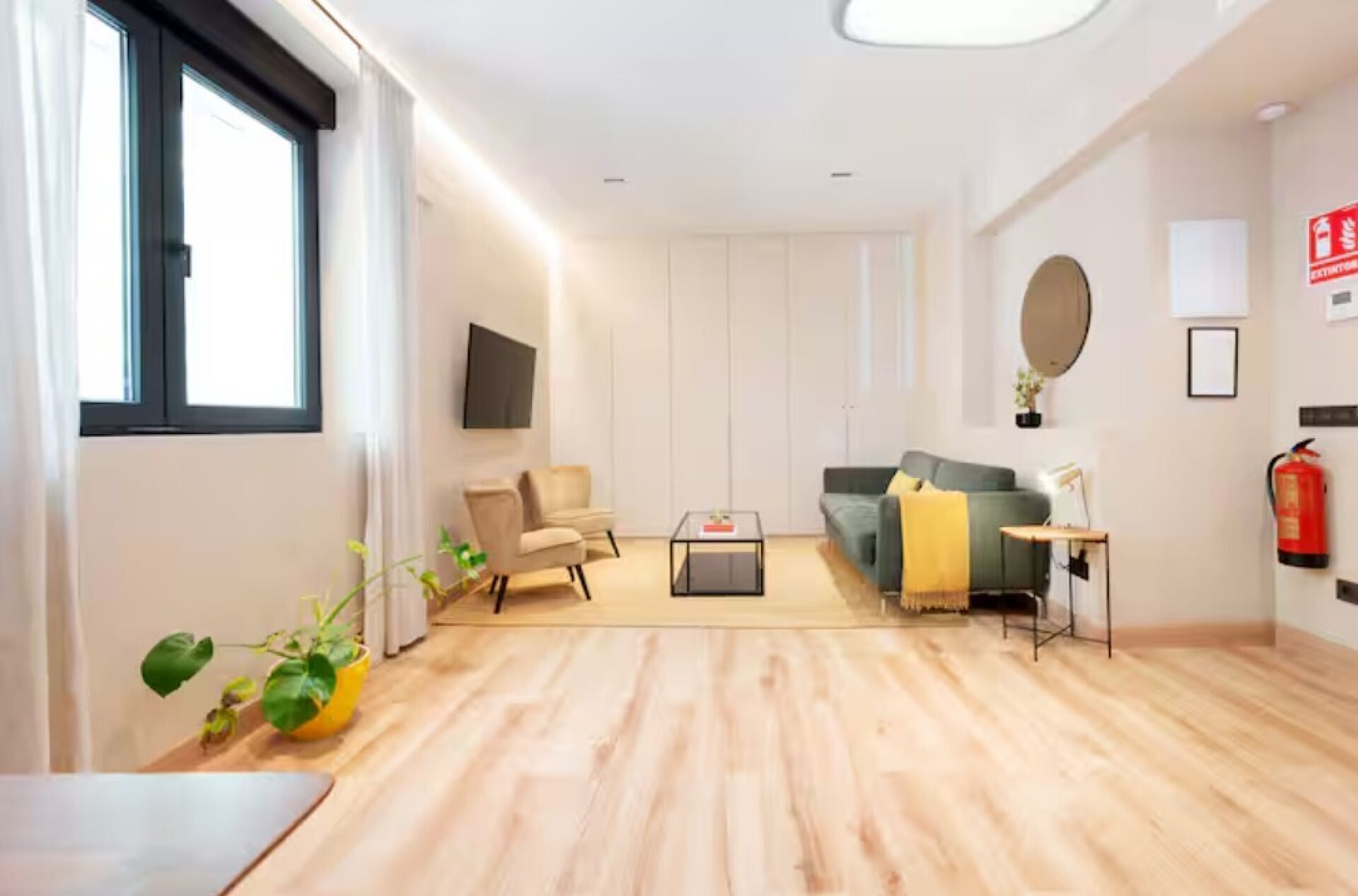 A modern living room with a sofa, armchairs, a coffee table, and a fireplace.