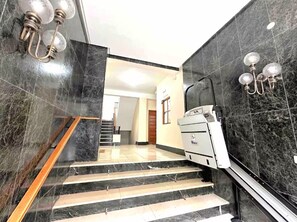 A staircase with marble walls and a modern elevator. - STAYMADRID - Chic Apartment (MADRID)