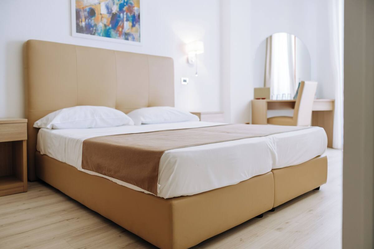 Una habitación de hotel moderna con una cama grande, un escritorio y una silla.