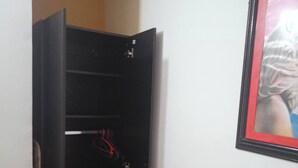 Una habitación con una cama, un armario y un cuadro en la pared.