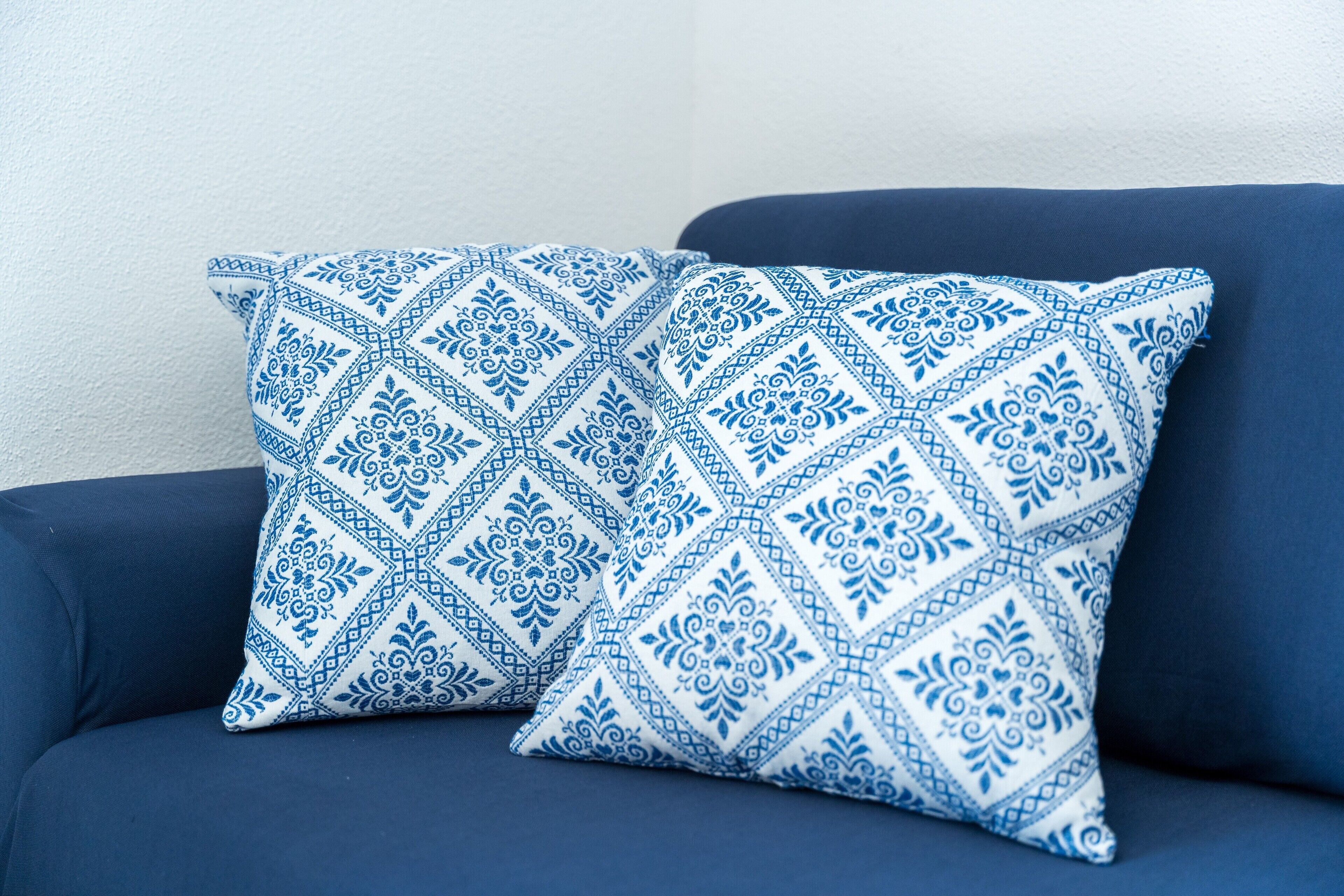 Un sofá azul con un cojín estampado.