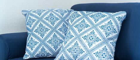 Un sofá azul con un cojín estampado.