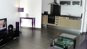 A modern living room with a flat-screen TV, a glass coffee table, and a sofa. - Between the upper town and the marina (Porto-Vecchio)