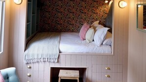 A cozy bedroom with a built-in bed, a small wooden table, and a chair. - Shepherds Hideaway (Holsworthy)