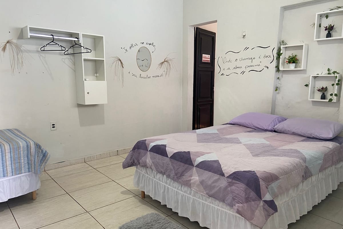 Une chambre à coucher avec un lit, une commode, un miroir et une porte.