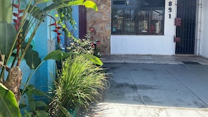 A building with a stone wall, a metal gate, and a window with the number 1891. - Açaizeiro Hostel (Belém)