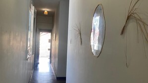 A hallway with a wooden floor, white walls, and a door at the end. - Açaizeiro Hostel (Belém)