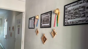 A hallway with framed photographs on the wall, a door, and an air conditioning unit. - Açaizeiro Hostel (Belém)