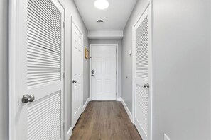 A narrow hallway with white doors and a wooden floor. - Two bedroom, Two Bathroom Condo| Pigeon Forge| Old Mill| Sleeps 6 (Pigeon Forge)