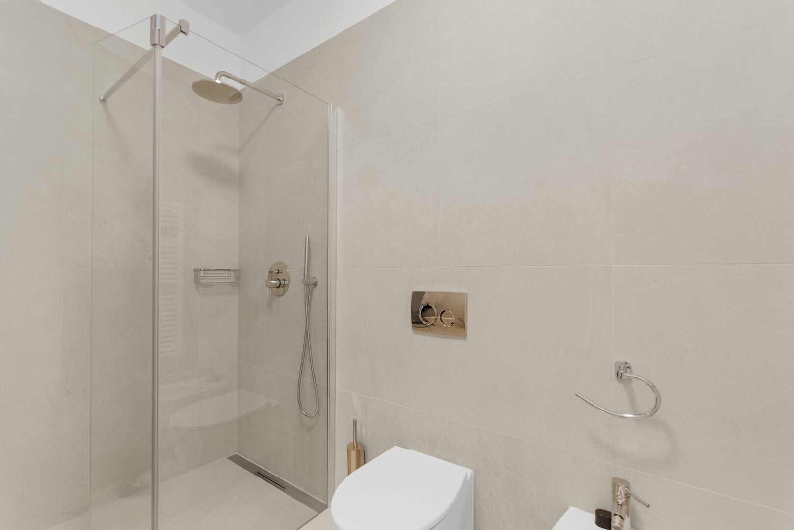 Une salle de bain moderne avec une douche à parois de verre, des toilettes et un lavabo.