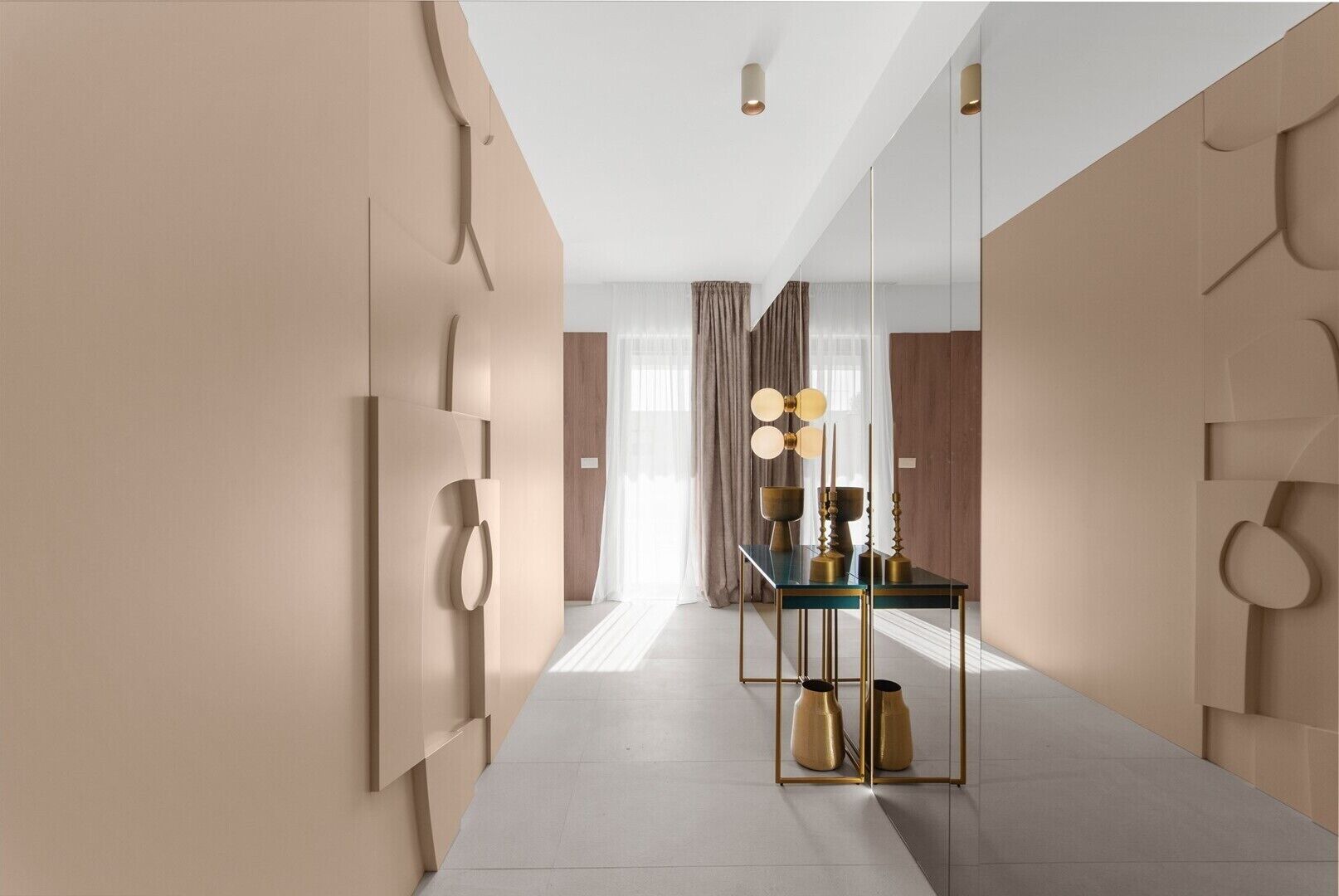 A modern hotel hallway with a reflective floor, a glass table with decorative items, and a mirror on the wall.