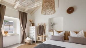 A bedroom with a bed, a dresser, a hanging light fixture, a window with curtains, and a plant on a shelf. - Charming Villa Vin with pool near Poreč (Brčići)