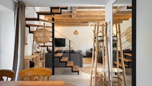 A modern living room with a staircase, wooden furniture, and a television. - Charming Villa Vin with pool near Poreč (Brčići)
