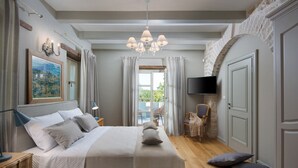 Een slaapkamer met een bed, nachtkastjes, een televisie en uitzicht op de omgeving.