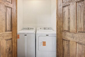 A laundry room with two white washing machines and wooden doors. - *Gorgeous 5BD Lodge w/ POOL! Hot Tub + Theater* (Sevierville)