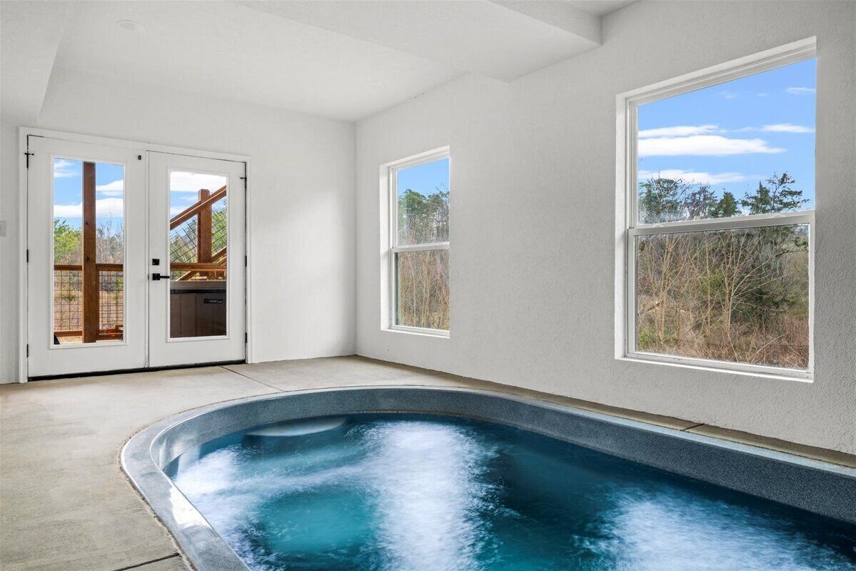 A spa area with a hot tub, large windows, and a view of the outdoors.