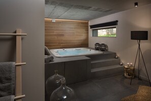 A modern bathroom with a freestanding bathtub, a window with a view, and a small seating area with candles. - Villa Melon with private pool for 10 people ner Poreč (Kirmenjak)