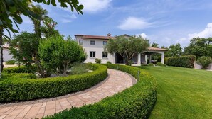 Un giardino curato con un vialetto sinuoso che conduce a una casa con tetto in tegole.