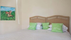 Ein Schlafzimmer mit einem Bett, einem Kopfteil und einem Bild von einem Reh in einem Feld.