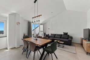 A modern living space with a dining area, a sofa, and a television. - Penthouse Stella Marini for 4+1 guests in Vabriga with Jacuzzi and sea view (Tar)