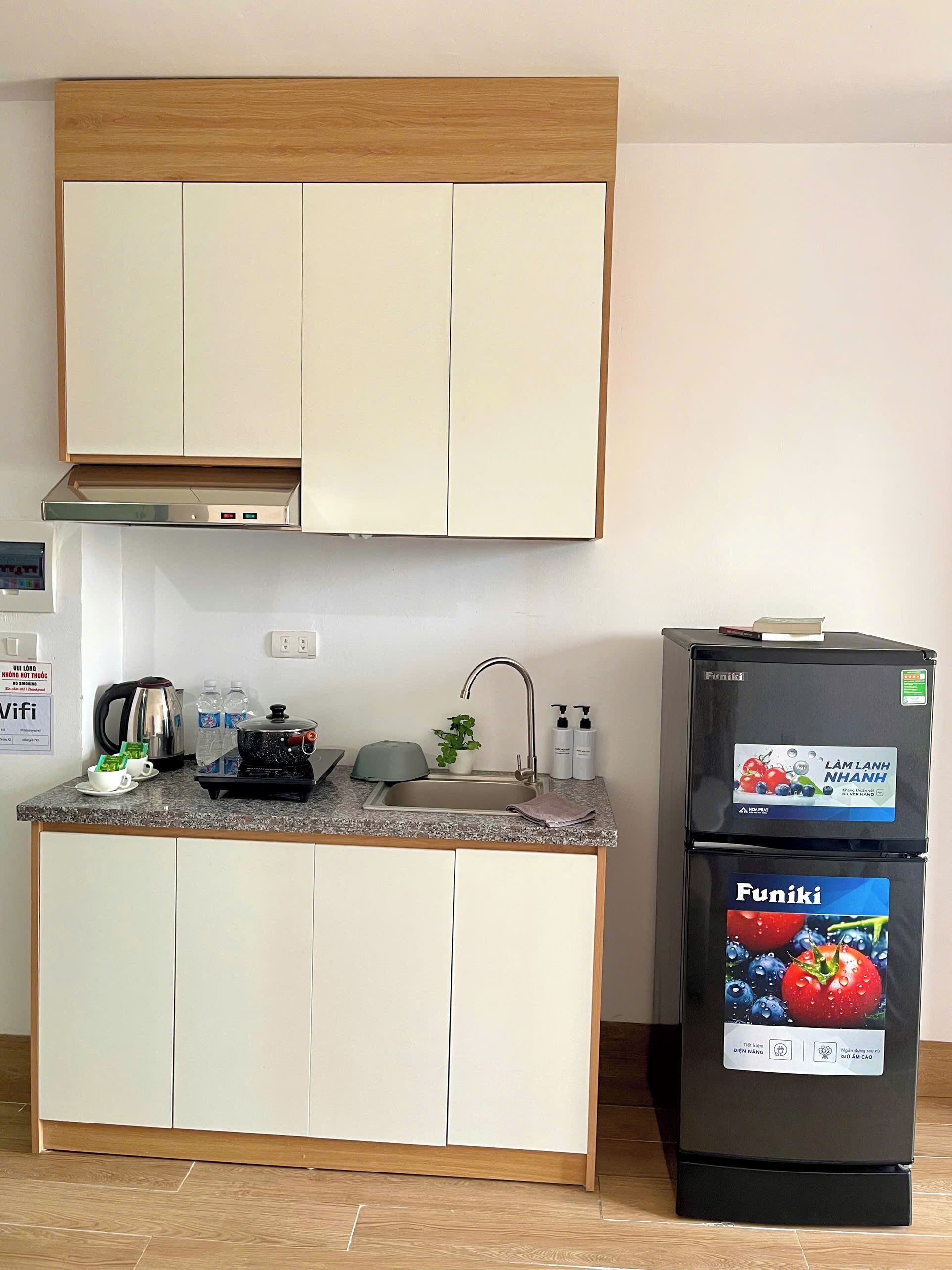A compact kitchen with a built-in oven, a sink, and a refrigerator.