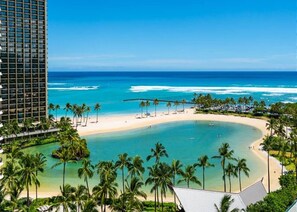 Ein Resort mit Blick auf den Strand, Palmen und einem klaren, blauen Meer.